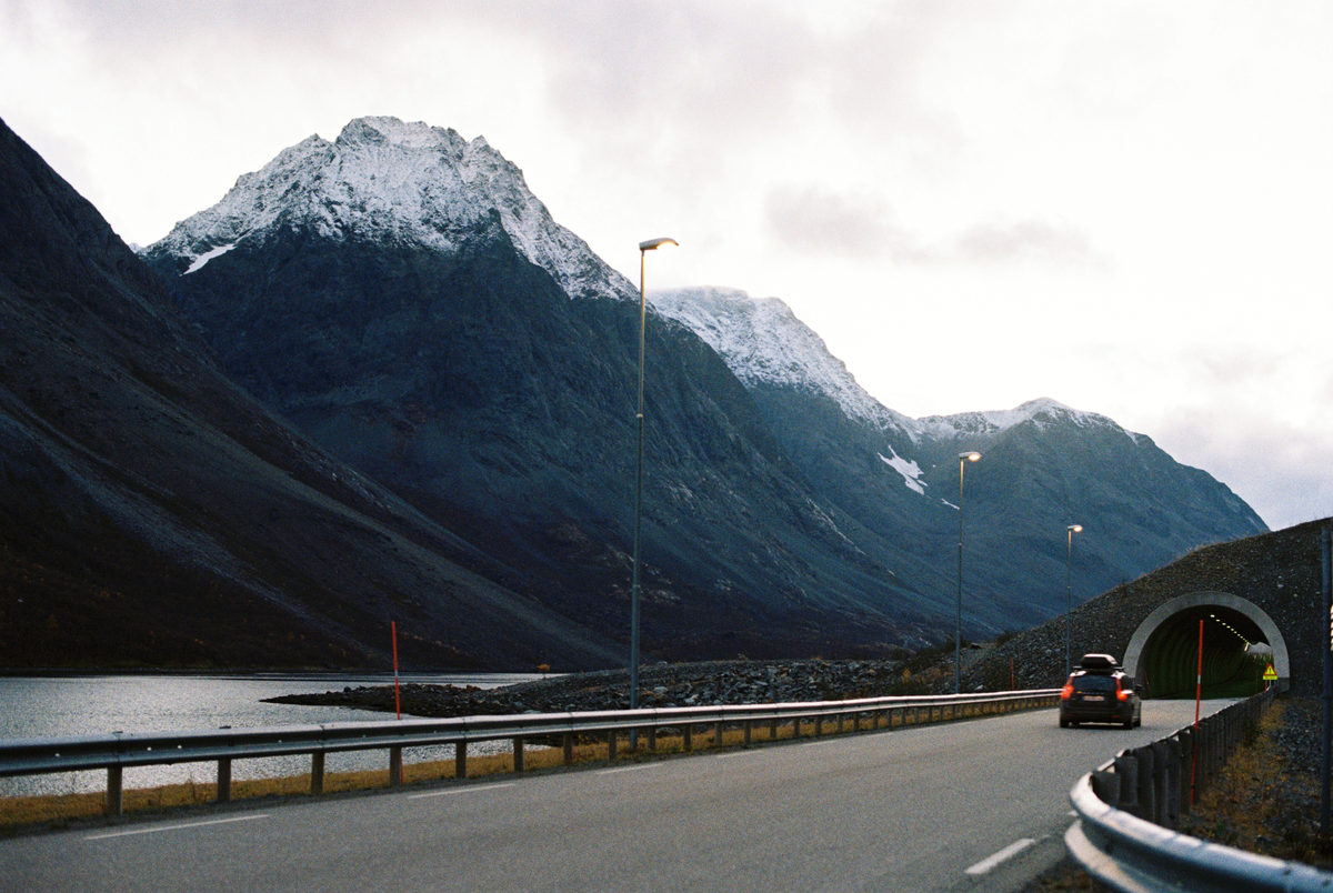 Snow-capped mountains above a winding coastal road